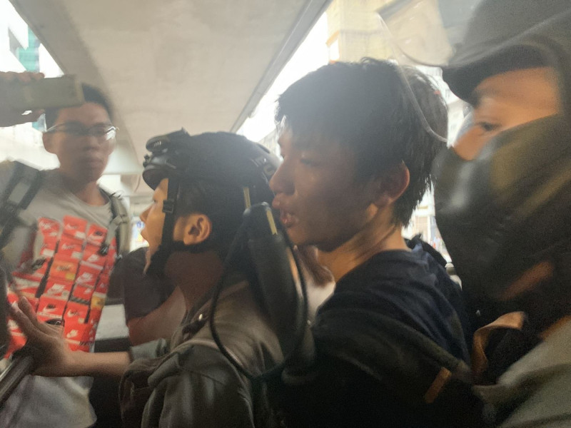 一名員警在觀塘apm出口通道遭一名黑衣示威者以刀割傷後頸，其後遭到警方制服逮捕。   圖：擷取自香港01