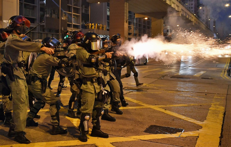 香港「反送中」示威者20日下午在九龍多處縱火，港警祭出水炮車清場，施放多枚催淚彈並拘捕數人。   圖：共同社提供