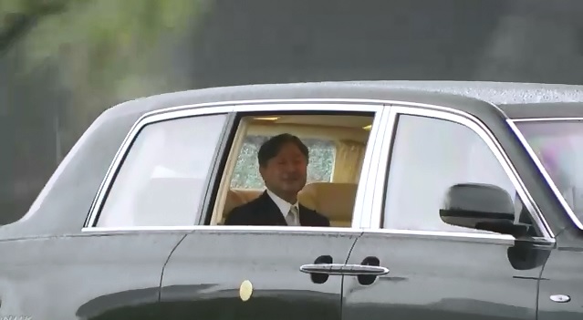 日本德仁天皇22 日一早驅車前往皇居，進行登基大典的準備，在駛入皇居前，他特別開窗向民眾致意。   圖：翻攝自NHK影片