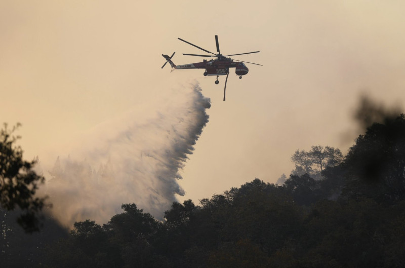 救災團隊派出直升機在空中灑水，幫忙滅火。   圖：翻攝自推特