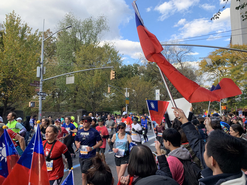 第49屆紐約市馬拉松當地時間3日舉辦，台灣跑者親友與本地僑胞熱情助陣，在中央公園外的跑道旁揮舞中華民國國旗替跑者加油。   圖：中央社提供