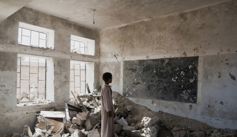1位葉門小朋友站在薩達區Aal Okab學校的教室廢墟中，非常茫然，4年的內戰，葉門國內就像這間學校般幾乎全毀於戰火。   圖：聯合國圖片