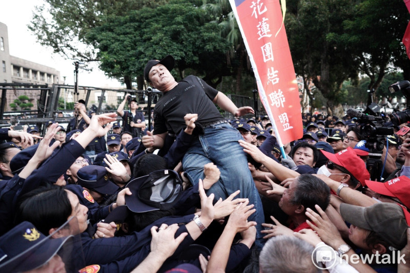 抗議退警試圖攀爬拒馬，進入行政院。   圖：張良一／攝