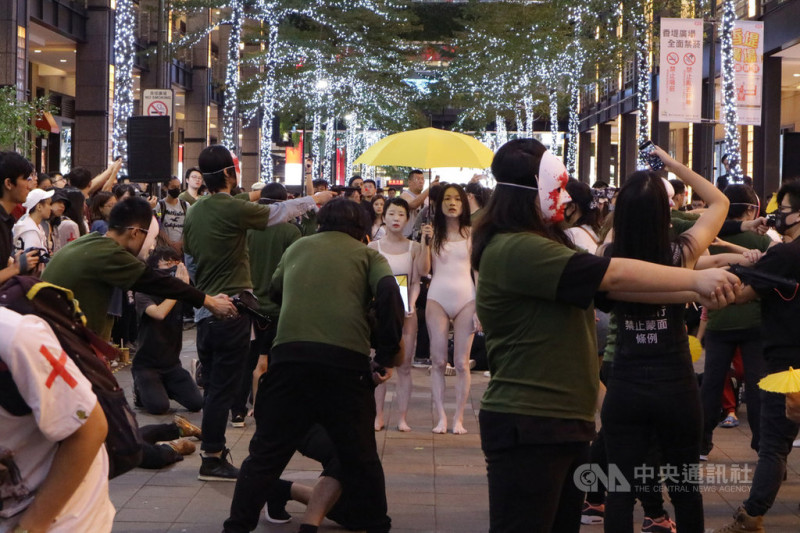 民間團體16日下午在台北街頭舉辦「香港縮時：一起喚醒對中共暴行仍無所知的人」行動劇，演出反送中街頭抗爭。   圖：中央社提供