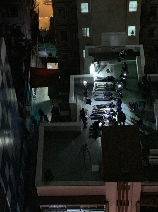 香港網友拍到港警在尖沙咀某處大樓屋頂，以對待戰俘方式虐待被捕的示威者，與港警自po影片不謀而合。   圖：翻攝自香港連登討論區