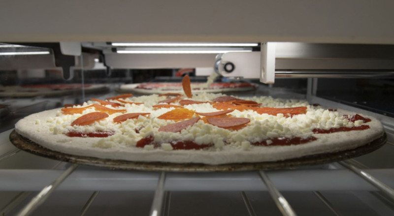 Picnic的披薩機器具備電腦視覺技術，能判斷餅皮尺寸，並根據不同模組鋪上蕃茄醬、起司、臘腸等多種配料。   圖：翻攝自Picnic官網