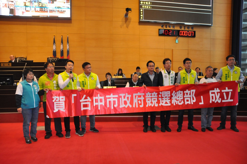 民進黨市議員舉起賀「台中市政府競選總部成立紅布條。   民進黨團/提供 