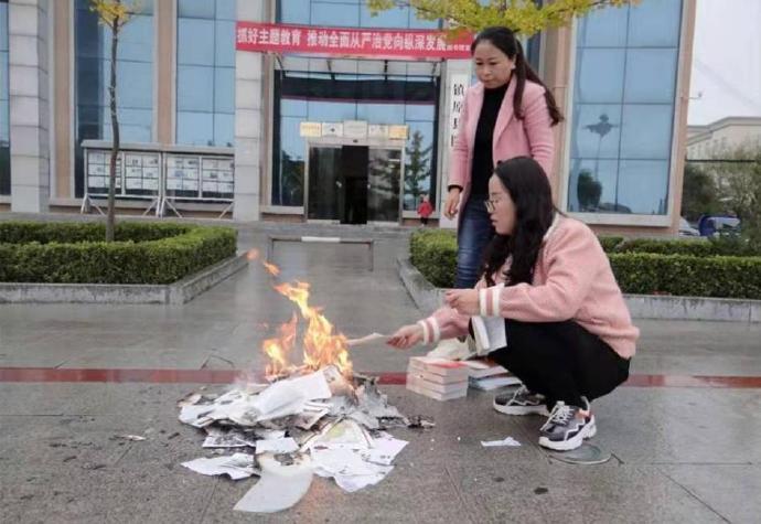 中國甘肅慶陽市鎮原縣立圖書館2名女性人員，在館前焚燒清理出來要下架的圖書，這個焚書的動作引發軒然大波。   圖：翻攝自微博/觀察者網