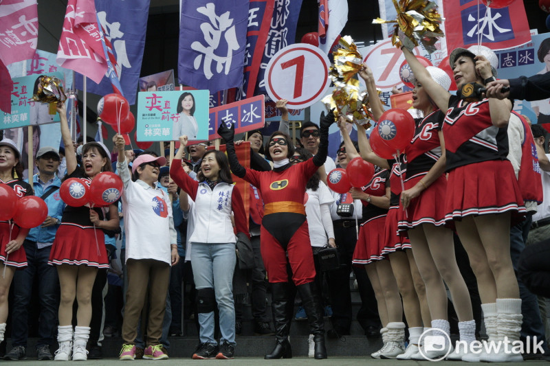 國民黨立委候選人汪志冰打扮成超人造型，一些志工也打扮成啦啦隊員在旁助陣。   圖：張良一/攝