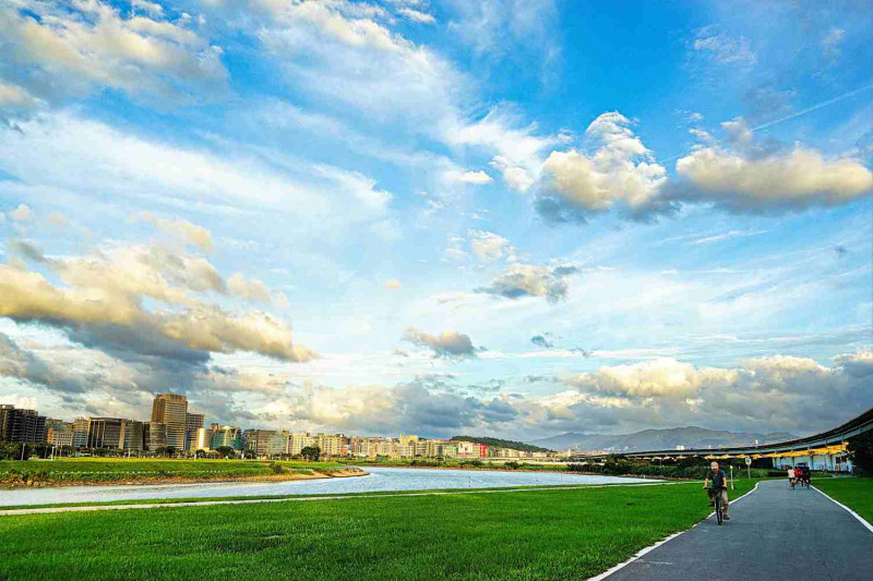 騎行「基隆河左右岸親水自行車道」，放眼望去盡是綠野草皮，十分遼闊。   圖：台北市政府／提供