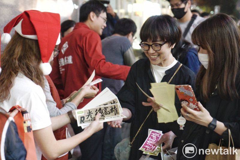 工作人員在現場發放「光復貼紙」，也有台灣基進的成員一同協助發放。   圖：張良一/攝