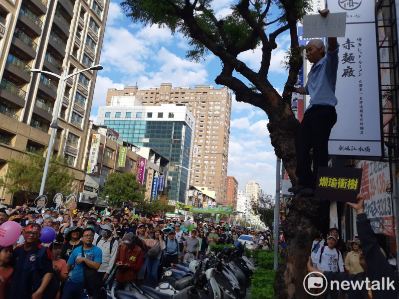 有人模仿韓國瑜爬樹查看登革熱疫情，諷「爛瑜衝樹」。   圖：蔡坤龍/攝