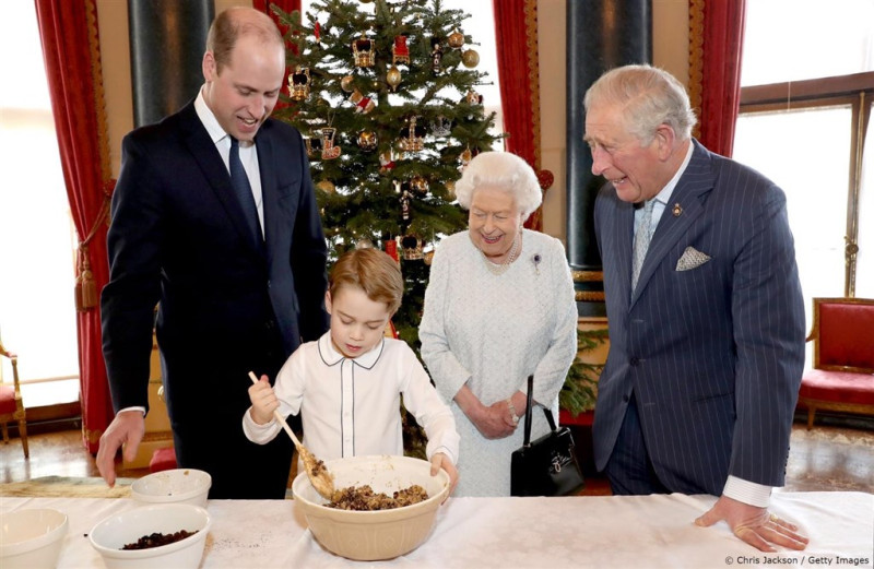 白金漢宮21日公布王室四代同堂製作耶誕節布丁的照片。喬治王子（左2）正在攪拌食材，父親威廉王子（左）、爺爺威爾斯親王（右）及曾祖母英國女王伊麗莎白二世（右2）在旁微笑看著。   圖（facebook.com/TheBritishMonarchy）