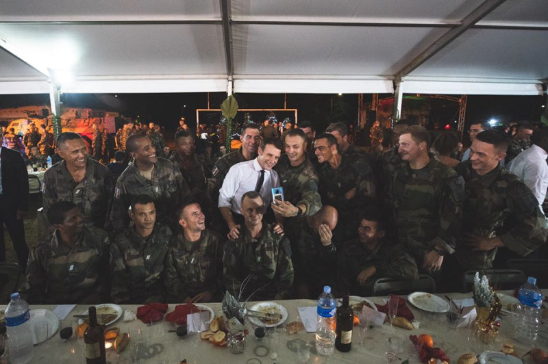 法國總統馬克宏（中穿白衣者）一向走親民路線，他訪問象牙海岸與駐軍同樂，還玩起自拍。   圖：翻攝自馬克宏臉書