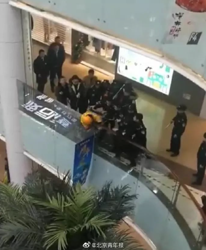 外送員試圖翻越護欄跳樓，但被保安制止   圖 : 翻攝自北京青年報