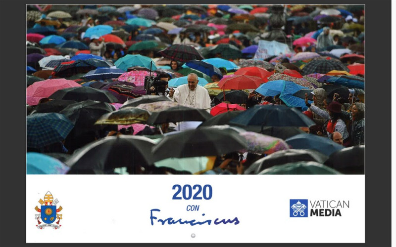 教廷2020年官方出版的教宗月曆封面是教宗與一群「撐著雨傘」的群眾合照，觀察家解讀是暗撐香港。   圖：中央社(翻攝月曆封面)