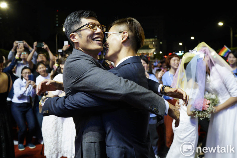 台灣伴侶權益推動聯盟在凱道席開160桌同婚宴，慶祝台灣同婚合法，1600人在會中同時舉杯高喊「還我紅包錢」。圖為一對男同性戀者在交換信物，完成結婚儀式後相互擁抱。   圖：張良一/攝