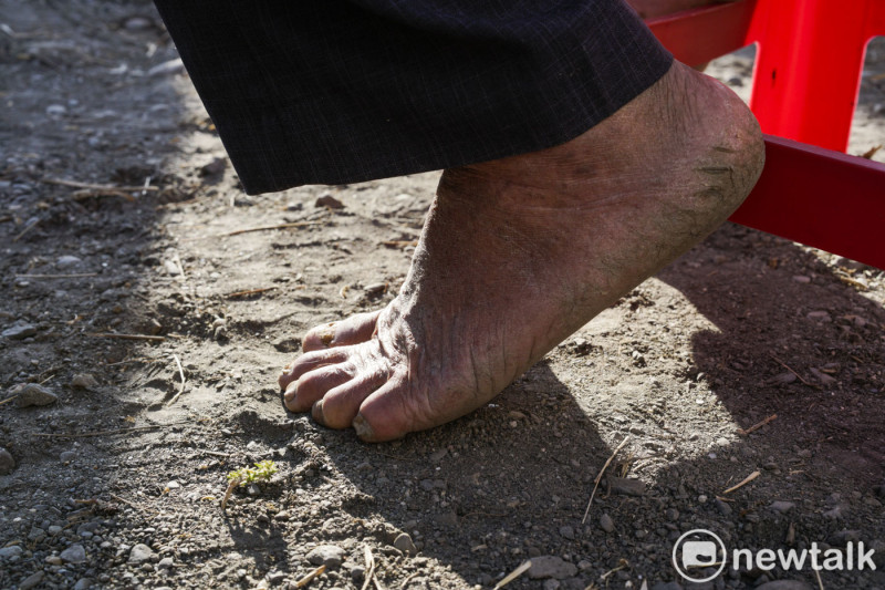 彰化縣福興鄉一位八十多歲的老農，結束田裏的工作後，打著赤腳到民進黨立委候選人的造勢活動會場。   圖：張良一 /攝