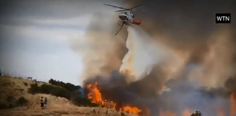 澳洲叢林野火危機持續惡化，滅火飛機從數個社區上空飛過，阻止火勢蔓延。   圖：翻攝Youtube