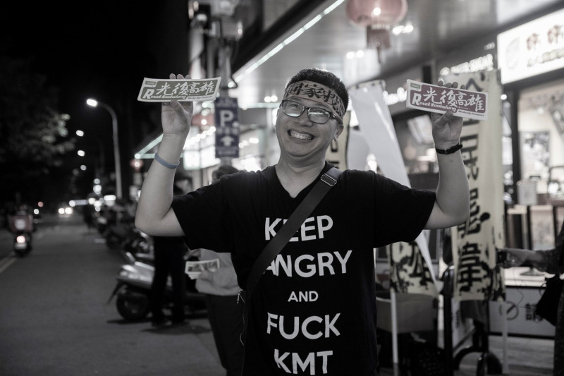 響應罷韓行動者7日晚間於台中一中街發放一萬八千張光復高雄貼紙，同時綁上回家投票頭巾，呼籲民眾1月11日回家投票。   圖:廖建超/提供
