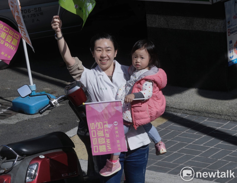 台中市區的一位媽媽聽到小英要來了的廣播後，抱著女兒從店裡衝出來。   圖：張良一/攝