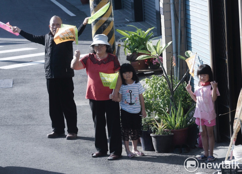 一位阿嬤帶著兩位小孫女在家門口等待小英掃街車隊到來。   圖：張良一/攝