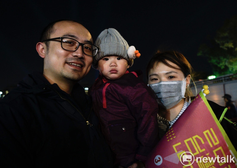 一對年輕的爸爸媽媽冒著低溫和寒風，帶著孩子去蔡英文在新竹竹北舉行的造勢晚會，為小英加油。   圖：張良一/攝