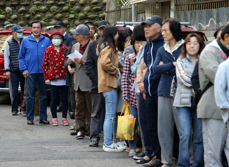 前總統馬英九（左2）一早就到住家附近的投票所，與民眾一起排隊投票。   圖：中央社