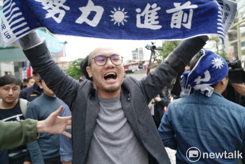 國民黨敗選檢討，一位青年高舉「努力前進」毛巾被趕出中央黨部。   圖：張良一/攝