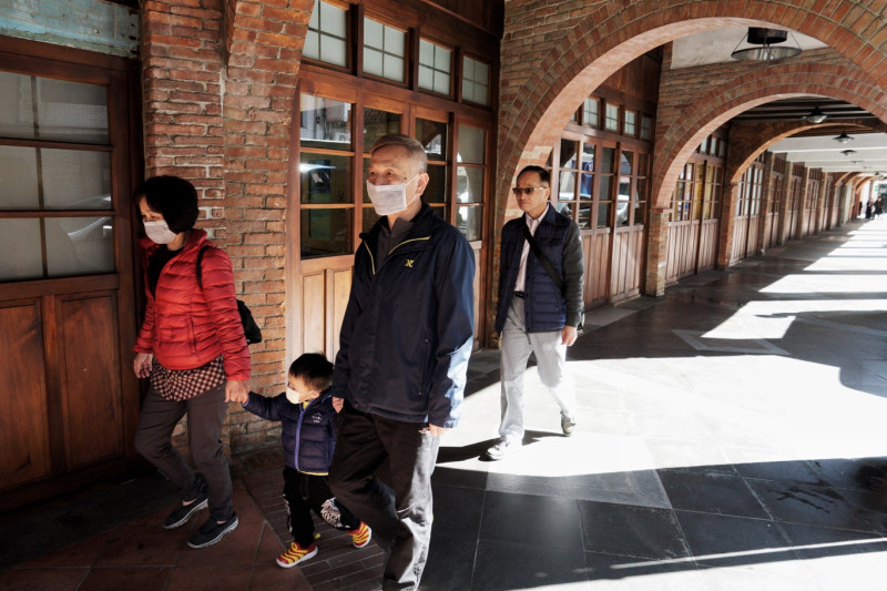 戴著口罩的家人走在萬華著名的剝皮寮歷史街區景點。   圖：張良一/攝