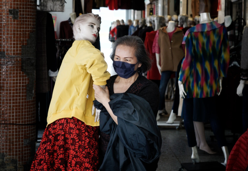萬華成衣商圈的店家將人形模特兒抬出來準備開始營業。   圖：張良一/攝