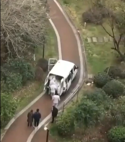 近日有一則37秒的中國影片在網路流傳，影片中穿著防護衣的工作人員疑似將一具遺體抬上車，車內也堆滿體。   圖：翻攝自twitter
