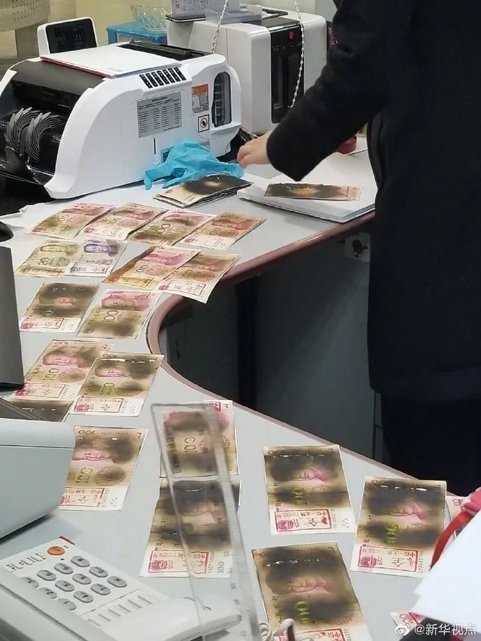 中國大陸民眾將人民幣紙鈔微波加熱消毒，變成了「炭烤鈔票」，銀行行員協助辨別兌換。   圖：翻攝自新華視點
