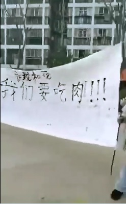 中國武漢市1月23日封城至今，因應習近平到訪，當地民眾舉白布條高喊「我們要吃肉」。   圖：翻攝自Ray Lau推特