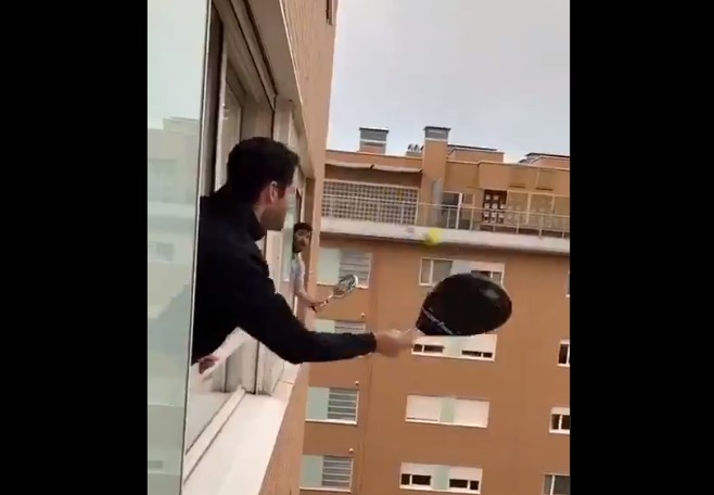 義大利民眾拿出球拍，探出高樓窗戶，和隔壁鄰居十分有默契地打起網球。   圖：翻攝自twitter