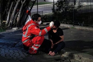 義大利紅十字會人員在街頭為弱勢族群量體溫、準備食物等，共同抗疫。   圖：翻攝自AJ+推特