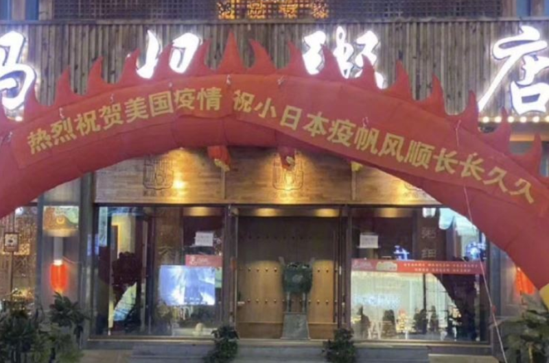中國瀋陽一家粥店於店門口放置充氣拱門，並掛上紅布條，斗大標語寫道「熱烈祝賀美國疫情，祝小日本疫帆風順長長久久」。   圖 : 擷取自微博