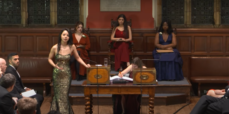 2015年加拿大世界小姐林耶凡（站立者）在牛津大學發表演說，痛批中共政權隱匿疫情，用人命做賭注來確保他們自己的統治。   圖：翻攝OxfordUnion YouTube