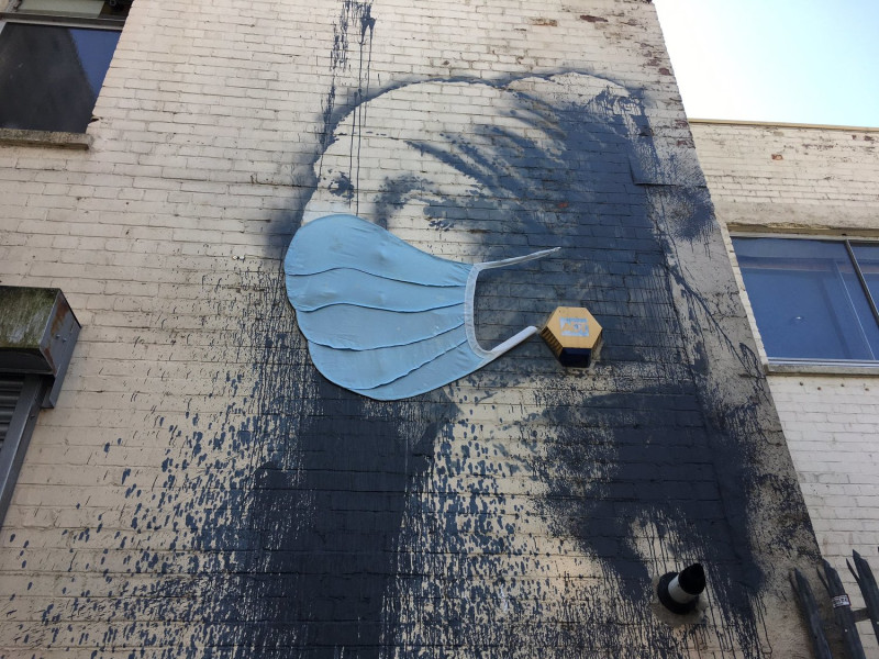 英國塗鴉畫《穿耳膜的少女》日前被發現戴上藍色的醫用外科口罩。   圖：翻攝自Twitter