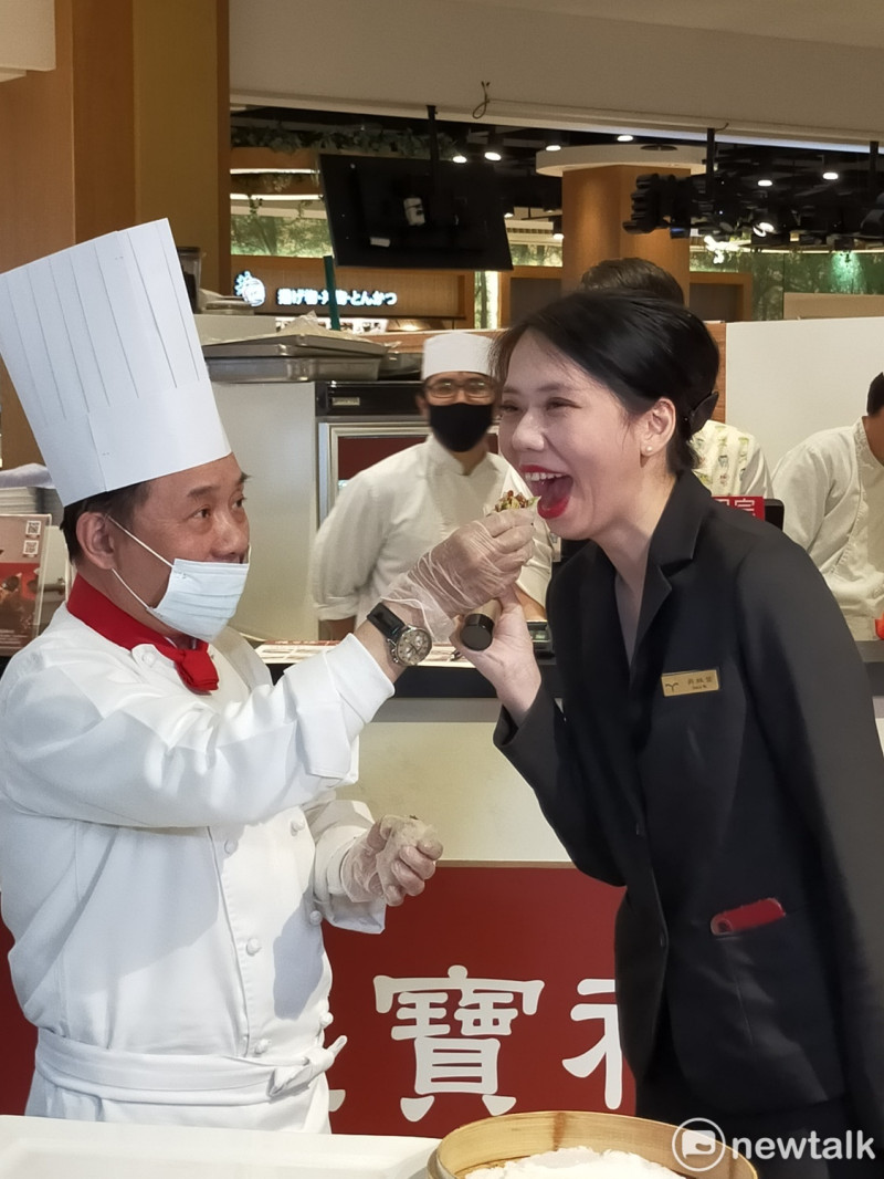 阿基師親自餵飯店美女公關吃烤鴨捲餅。   唐復年/攝