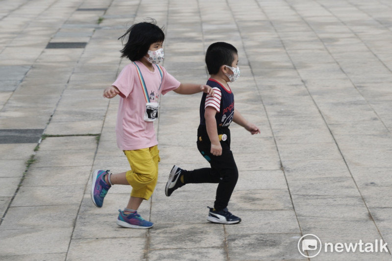 小朋友戴著口罩在河濱公園奔跑玩耍。   圖：張良一/攝