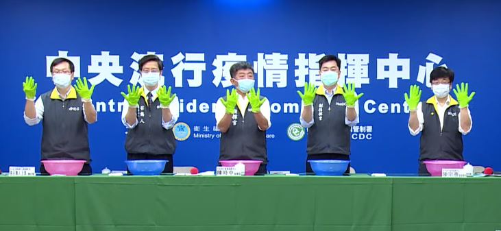 中央流行疫情指揮中心用綠色顏料代表肥皂，集體示範如何正確洗手。   圖：翻攝自疾管署直播影片