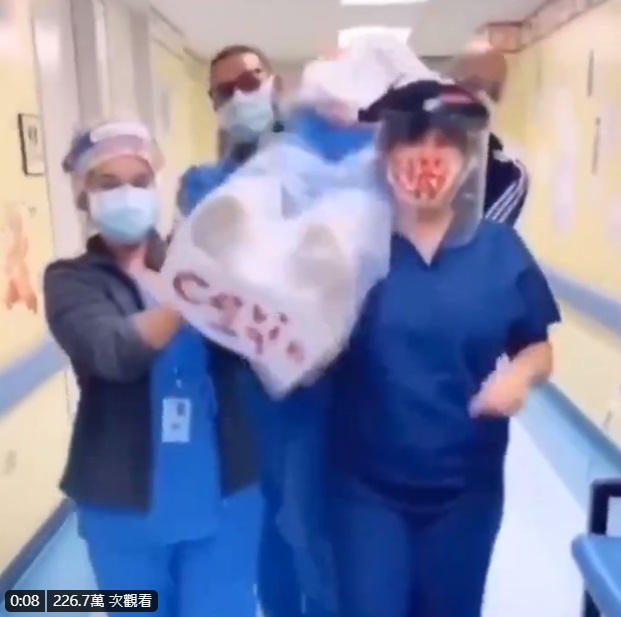4名醫護人員肩膀扛著寫有「COVID-19」的屍袋，跳著「抬棺舞」。   圖：翻攝自推特
