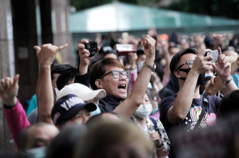 至少兩千位高雄旅北民眾在台北車站外等待領取罷韓布條前，高舉罷韓手勢並呼喊罷韓口號。   圖：張良一/攝