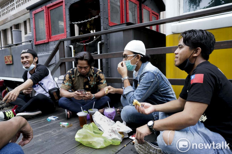來自印尼的穆斯林移工由於不能在北車一樓的車站大廳席地而坐共享開齋節美食，只能坐在車站外頭。   圖：張良一/攝