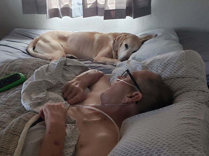 美國一名退役消防員被診斷罹患胰腺癌之後在家靜養，狗狗加納寸步不離地守在最愛的把拔身邊。   圖／FB@Heather Nicoletti