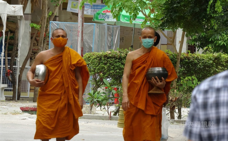 泰國官員28日表示，7月起將完全解禁。圖為泰國寺廟僧侶戴口罩，托著缽準備前往食堂用餐。   圖：中央社／提供