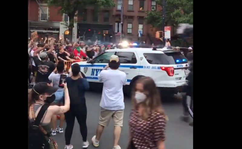 美國明尼蘇達州1名非裔男子，日前遭到白人員警膝蓋壓頸，導致窒息死亡，此事件引起全美各地引發抗議活動。30日在紐約市抗爭中，紐約市警局2輛警車疑似示威人群擋道，竟直接衝撞人群，導致多人摔倒在地。   圖：翻攝自@chieffymac11推特