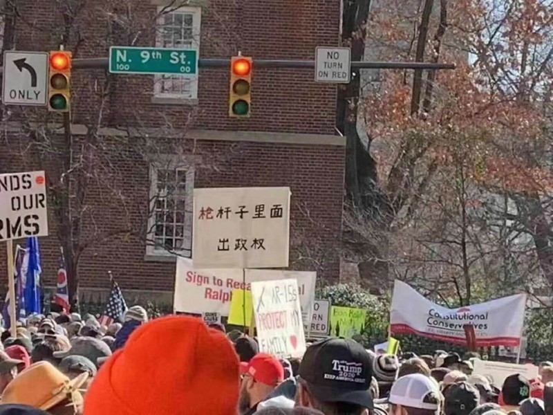 該訊息附帶的照片中可見抗議人潮中竟出現「槍桿子裡面出政權」的中國標語。   圖：翻攝微博