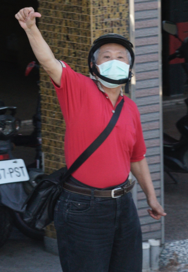 一位高雄市民對著罷韓掃街車隊機動的倒比姆指。   圖：張良一/攝